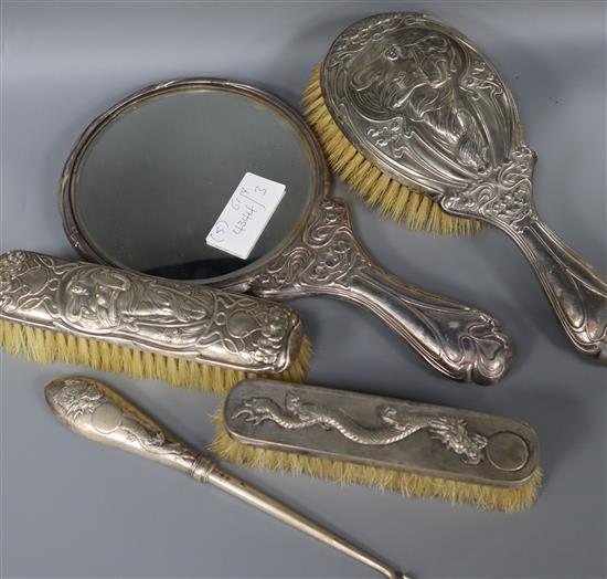 An Art Nouveau silver three piece dressing table set and Chinese white metal brush and buttonhook